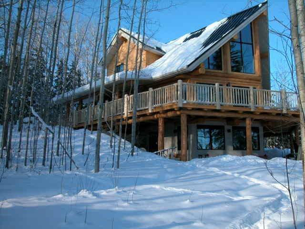 Snow covering a portion of the log home