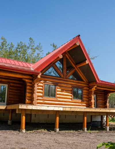 A log home with a red roof